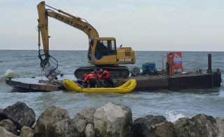 The Coast Guard pulls an injured man from a dredge barge in Lake Erie. USCG photo.
