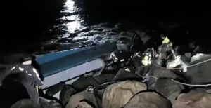 The first crewman to emerge from the overturned Pacific Miner reaches the top of a Coos Bay jetty after firefighters sawed a hole in the hull. Video still courtesy Basin Tackle Charleston.