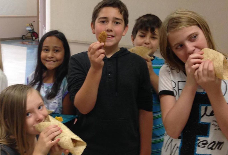 Students enjoying fish sticks made with Alaska Pollock. Photo courtesy Alaska Pollock - Great Fish for Great Kids Facebook page.