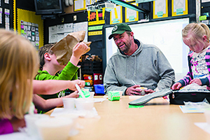 Fisherman Greg Cushing, husband of school cook Debbie Cushing, joins students at Sitka's Baranof Elementary School for a local fish lunch. Adam Andis/Sitka Wild photo.