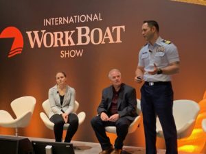Cmdr. Carlos Crespo of the Coast Guard's Office of Boat Forces, right, talks about small boat acquisition with Mark Porvaznik and Jen Sokolower at the International WorkBoat Show. Kirk Moore photo.