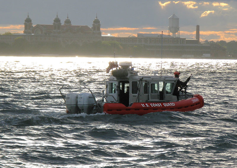 US Coast Guard small boat in New York Harbor at dusk.